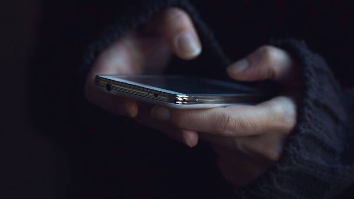 hands-with-cell-phone-dark-room-stock.jpg