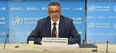 Dr. Tedros Adhanom Ghebreyesus, Director General de la OMS, habla en un atril con el logo de la Organización Mundial de la Salud al fondo.