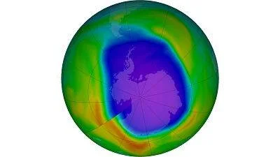 Visualización satelital del agujero en la capa de ozono sobre la Antártida, mostrando una gran zona azul-violeta de baja concentración.
