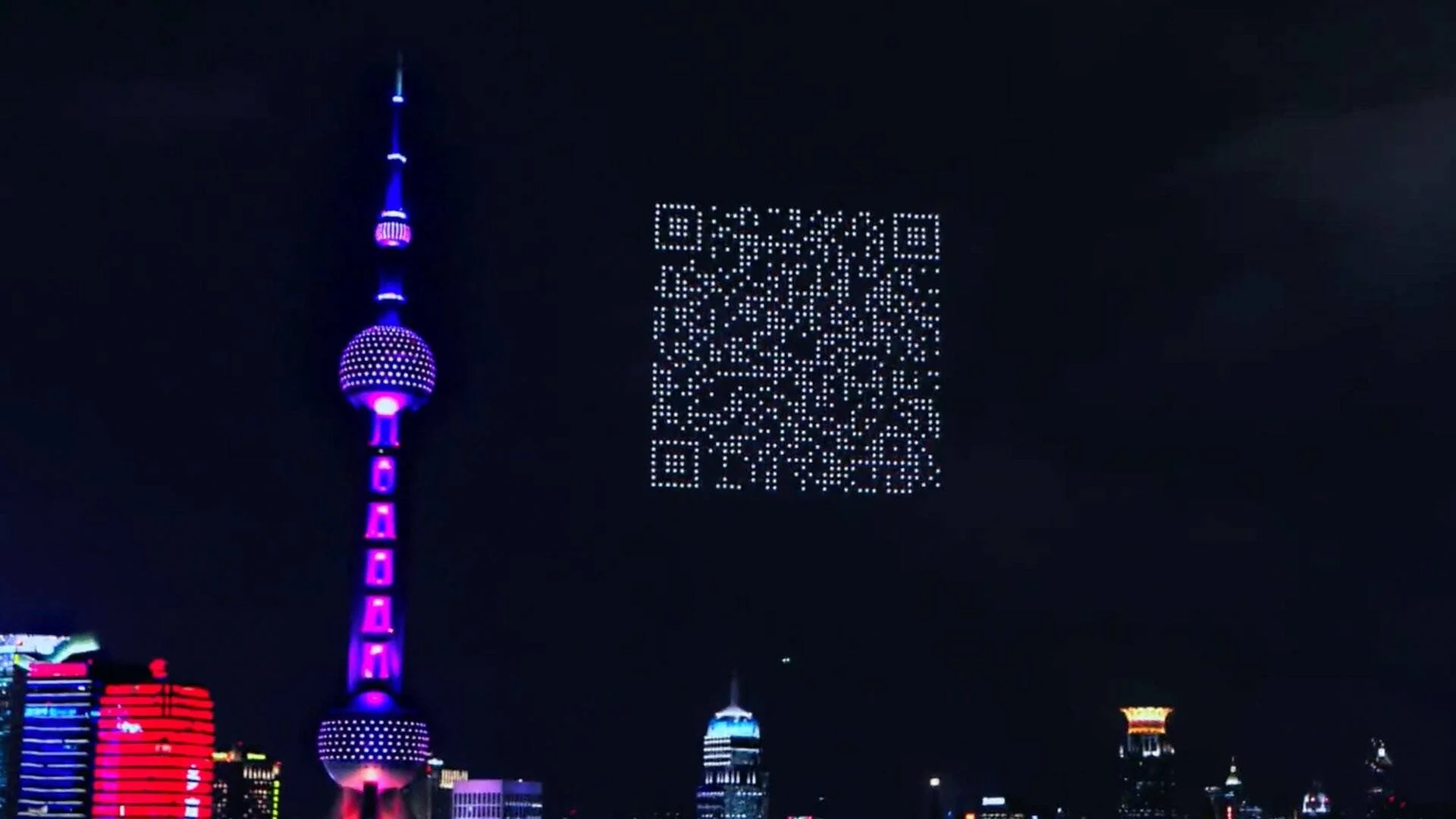 Enjambre de drones iluminados forma un código QR gigante en el cielo nocturno de Shanghái junto a la Torre Oriental.