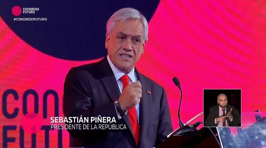 Sebastián Piñera, Presidente de la República, habla en el podio del Congreso Futuro ante un fondo iluminado en rojo.