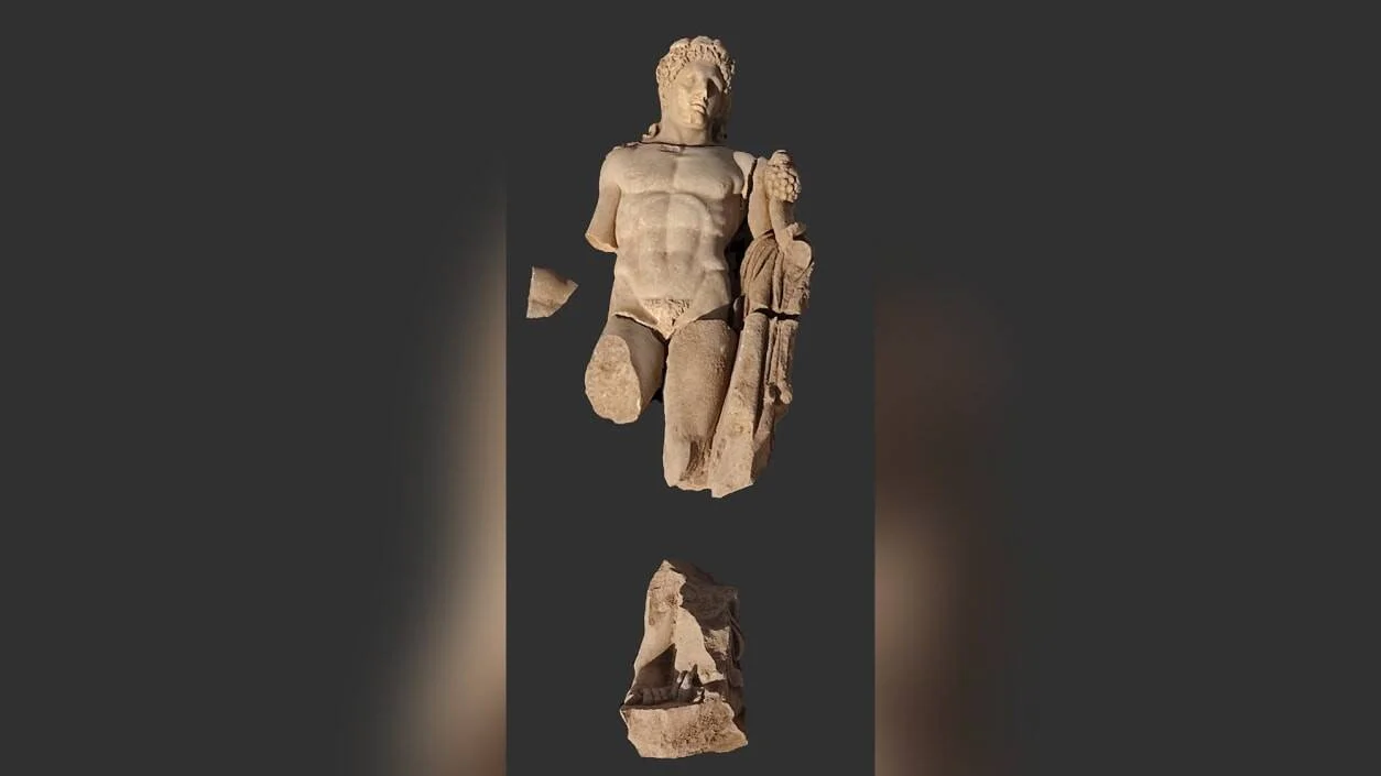 Estatua de mármol antigua de figura masculina semidesnuda con fragmentos separados, de estilo grecorromano.