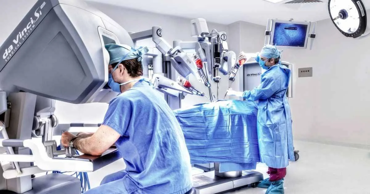 Dos profesionales de la salud realizan una cirugía asistida por el robot da Vinci en un quirófano moderno.