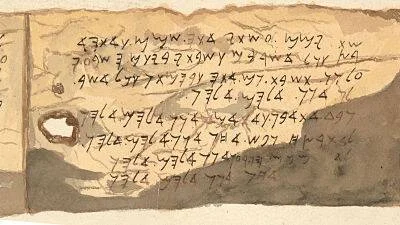 Fragmento de pergamino antiguo con inscripciones en escritura aramea o fenicia, con manchas de deterioro.