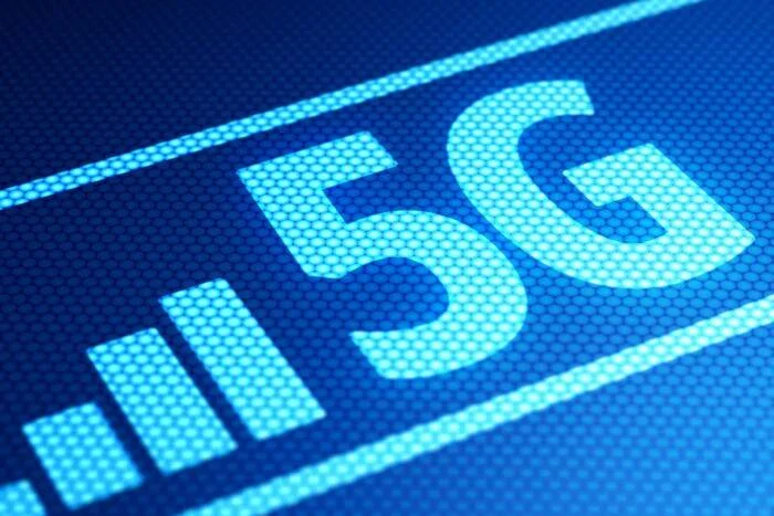 Logotipo 5G iluminado en azul junto a barras de señal, representando la tecnología de quinta generación de telecomunicaciones.