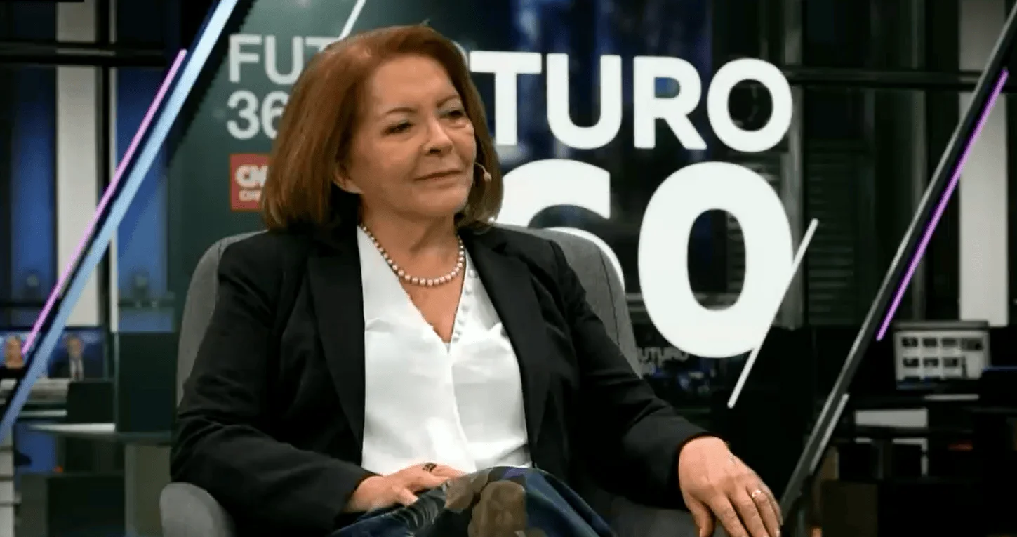 Mujer de cabello castaño con blazer negro y collar de perlas sentada en estudio del programa Futuro 360 de CNN.