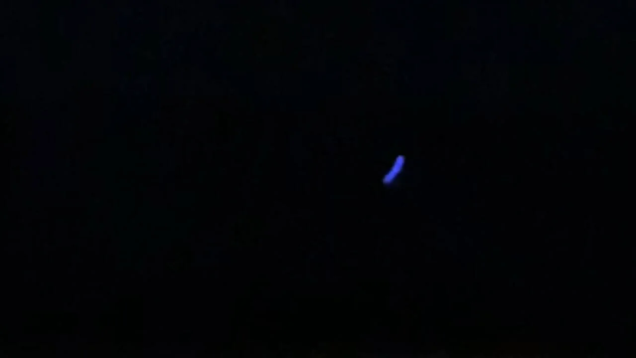Pequeño destello de luz azul brillante en medio de una imagen completamente oscura.
