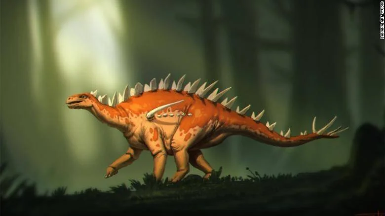 Reconstrucción artística de un estegosaurio de color naranja con placas dorsales, caminando en un bosque prehistórico.