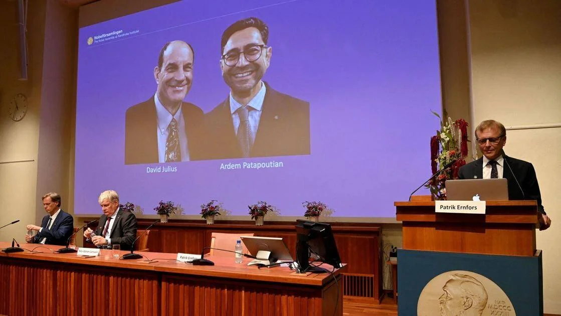 Patrik Ernfors anuncia el Premio Nobel de Medicina 2021 para David Julius y Ardem Patapoutian, proyectados en pantalla gigante.