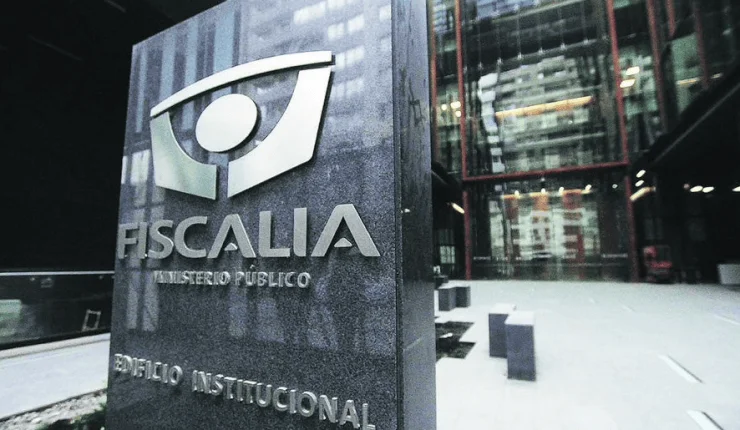 Cartel de piedra oscura con el logo y el nombre de la Fiscalía - Ministerio Público frente a su edificio institucional.