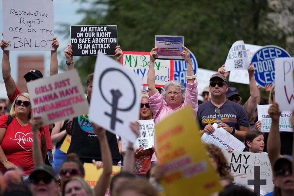 Multitud de manifestantes sosteniendo carteles en defensa de los derechos reproductivos y el acceso al aborto seguro.