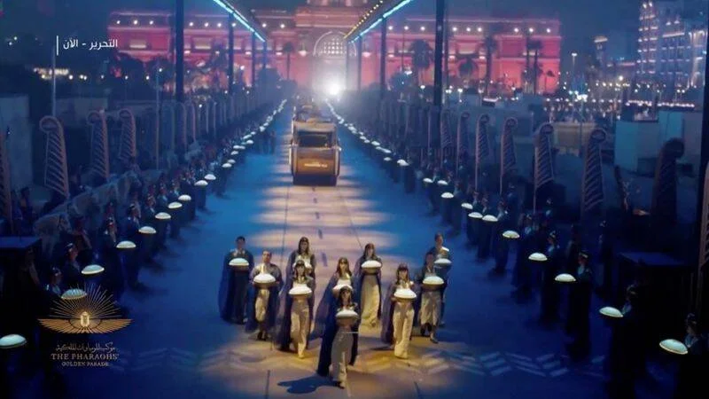 Ceremonia nocturna del Desfile Dorado de los Faraones con participantes en trajes egipcios escoltando momias reales por las calles de El Cairo.