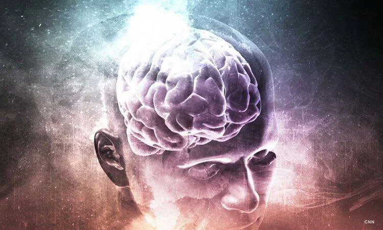 Representación artística de una cabeza humana con el cerebro visible y luminoso sobre un fondo cósmico abstracto.