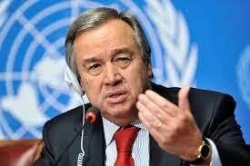 Hombre con traje oscuro y corbata roja habla ante micrófonos frente al logotipo de la ONU.