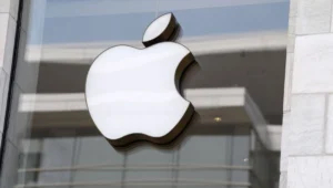 Logo iluminado de Apple sobre el vidrio de la entrada de una Apple Store.
