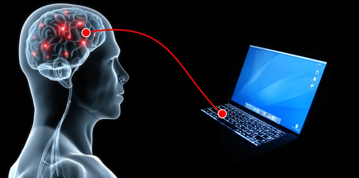 Ilustración de una cabeza humana con cerebro visible conectado a una laptop mediante una línea roja, representando una interfaz cerebro-computadora.