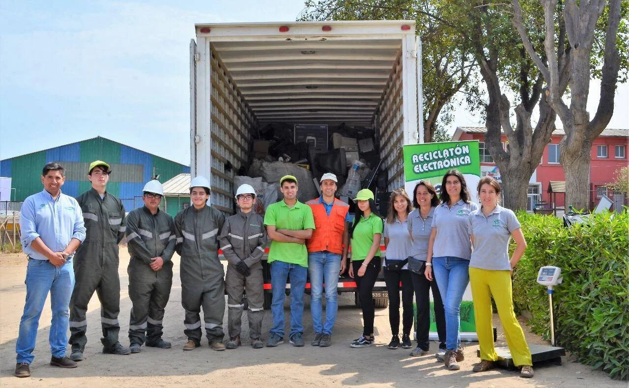 Grupo de personas posa frente a un camión cargado con residuos electrónicos en una jornada de Reciclatón Electrónica.