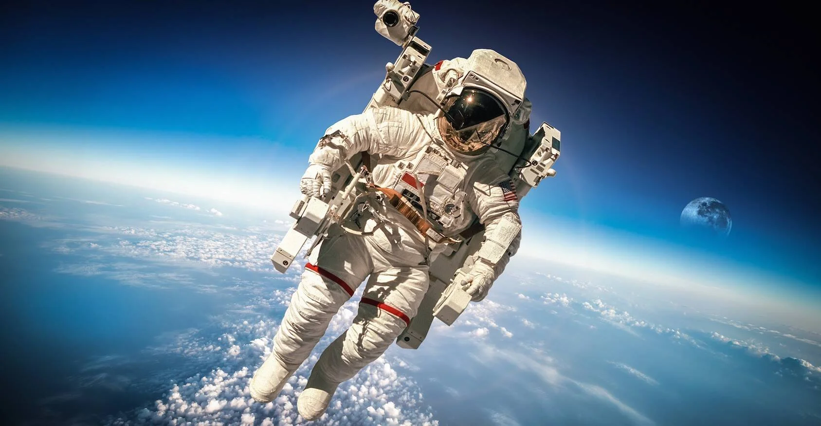 Astronauta con traje espacial blanco flotando en órbita sobre la Tierra, con nubes y atmósfera visibles al fondo.