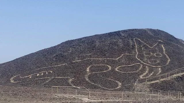 Geoglifo en forma de felino trazado sobre la ladera de un cerro árido en las Líneas de Nazca, Perú.