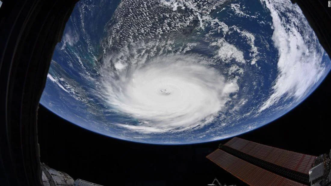 Ojo y espiral de un huracán fotografiados desde la Estación Espacial Internacional con paneles solares visibles en primer plano.