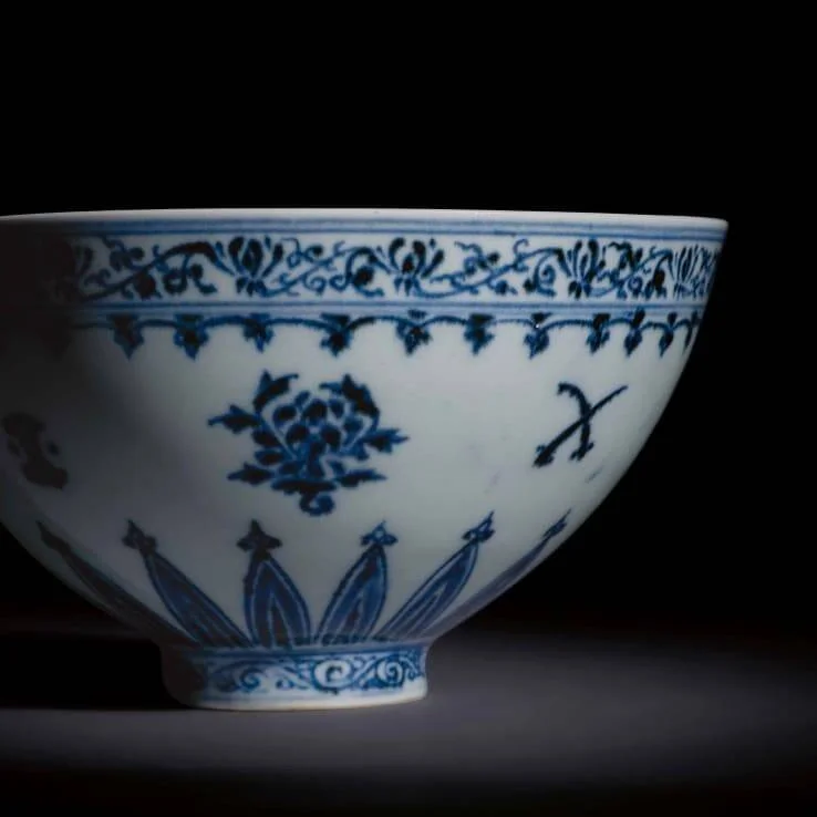 Cuenco de porcelana china con decoración floral en azul cobalto sobre fondo blanco, con motivos de loto y cenefas de roleos.