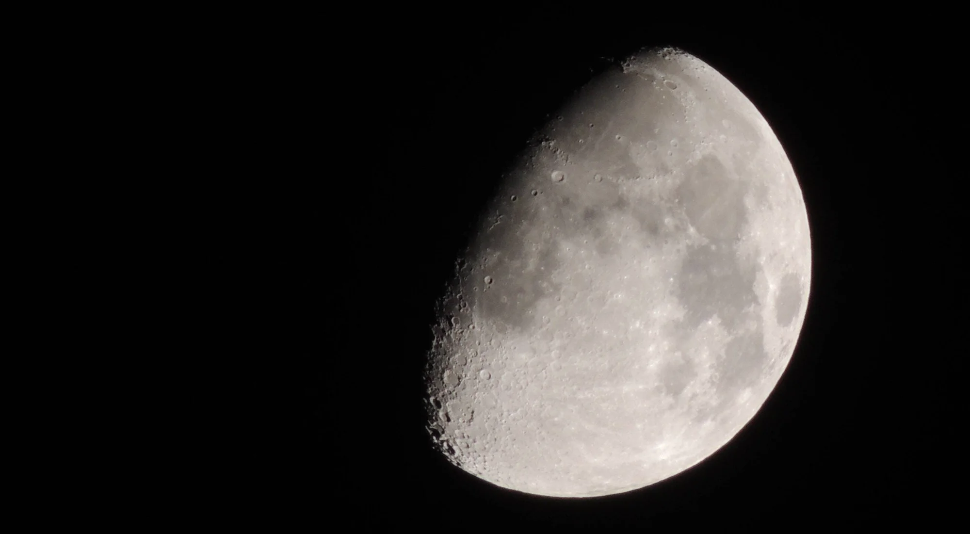 La Luna en fase creciente gibosa muestra con detalle sus cráteres y mares lunares sobre un fondo negro.