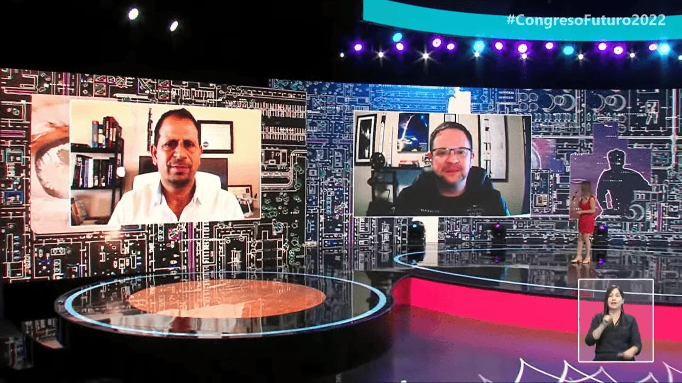 Escenario del Congreso Futuro 2022 con dos expositores conectados en videollamada proyectados en pantalla gigante y una presentadora en el estudio.