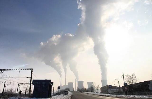 Torres de refrigeración y chimeneas de una central térmica expulsan grandes columnas de vapor en un día frío e invernal.