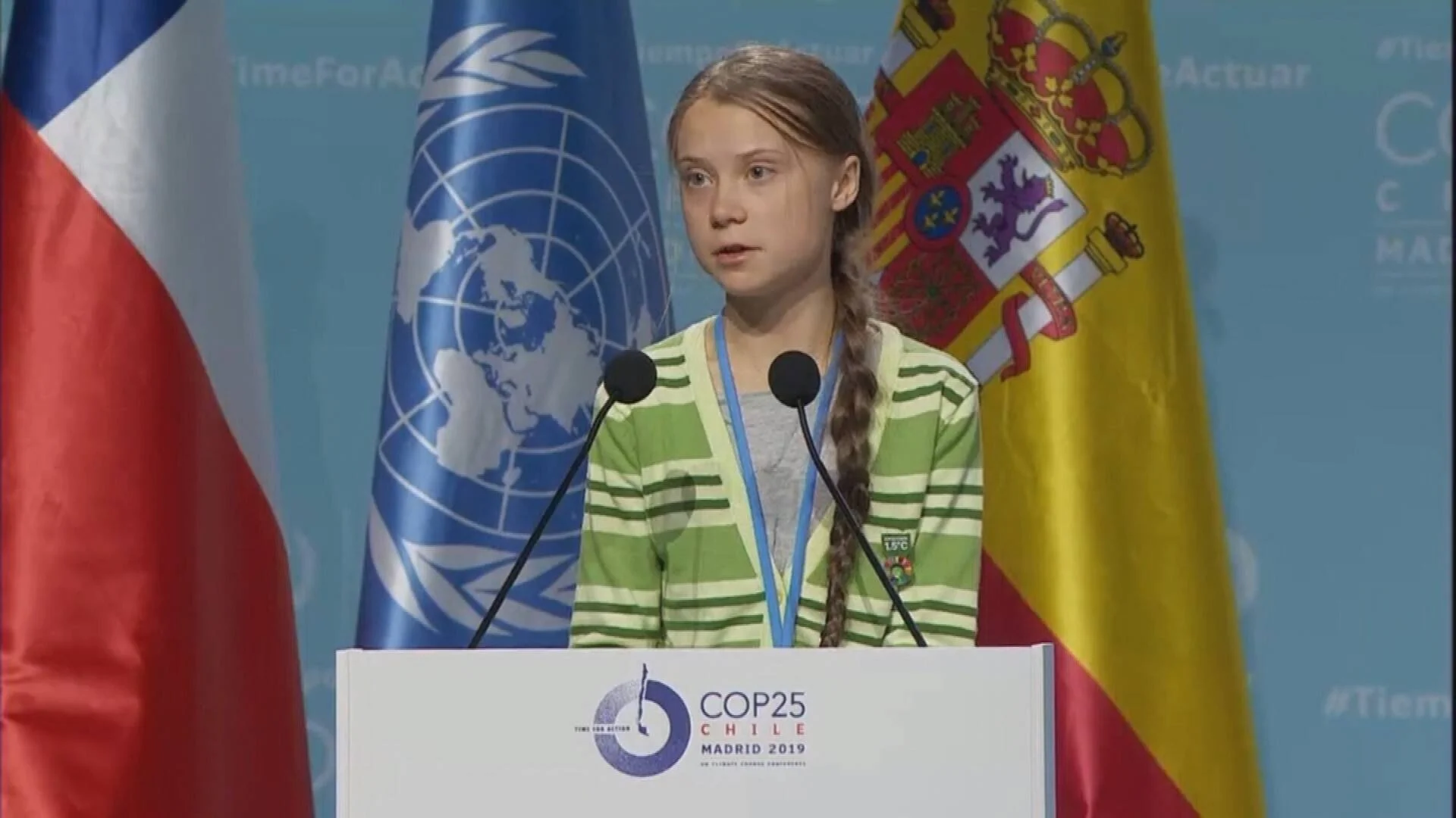 Una joven habla en el podio de la COP25 celebrada en Madrid en 2019, con banderas de Chile, la ONU y España al fondo.