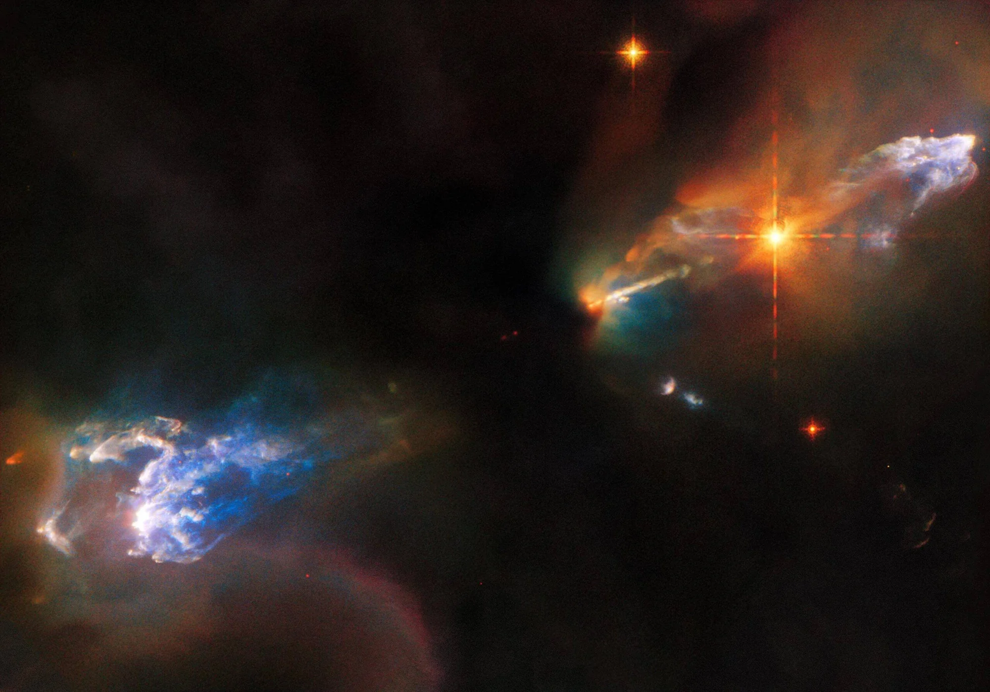 Dos jets de protoestrellas con nubes de gas azul y naranja emitiendo chorros de material en una región de formación estelar.