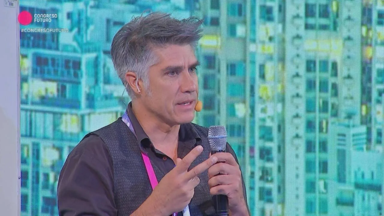 Hombre con cabello gris habla con micrófono en mano durante una presentación en el Congreso Futuro.