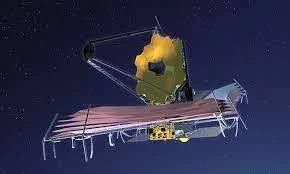 Telescopio espacial con espejos hexagonales dorados desplegados, flotando en el espacio estrellado.