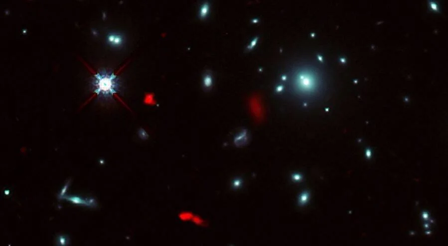 Campo estelar profundo con galaxias azules y objetos resaltados en rojo, captado por telescopio espacial.