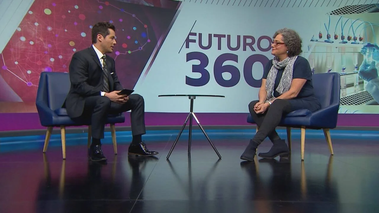 Un conductor y una invitada conversan sentados en sillones en el estudio del programa televisivo Futuro 360.