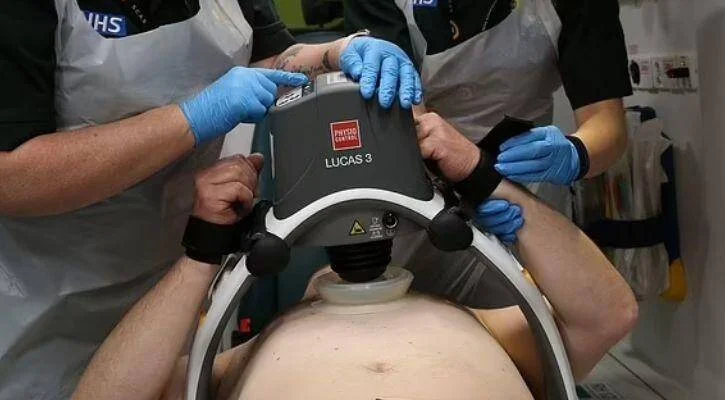 Personal del NHS coloca el dispositivo de compresiones torácicas automáticas LUCAS 3 sobre el pecho de un paciente.