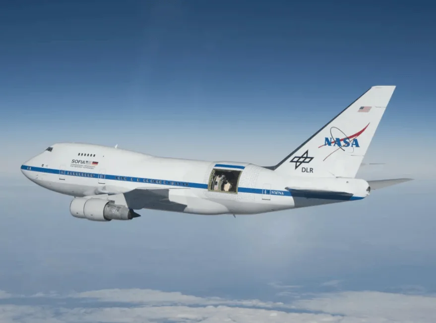 Boeing 747SP SOFIA de la NASA y DLR volando a gran altitud con la compuerta del telescopio abierta en el fuselaje.