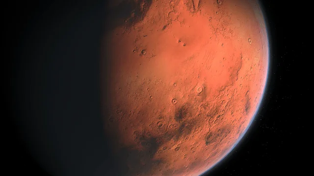 Vista del planeta Marte desde el espacio, mostrando su superficie rojiza con cráteres y fondo negro.