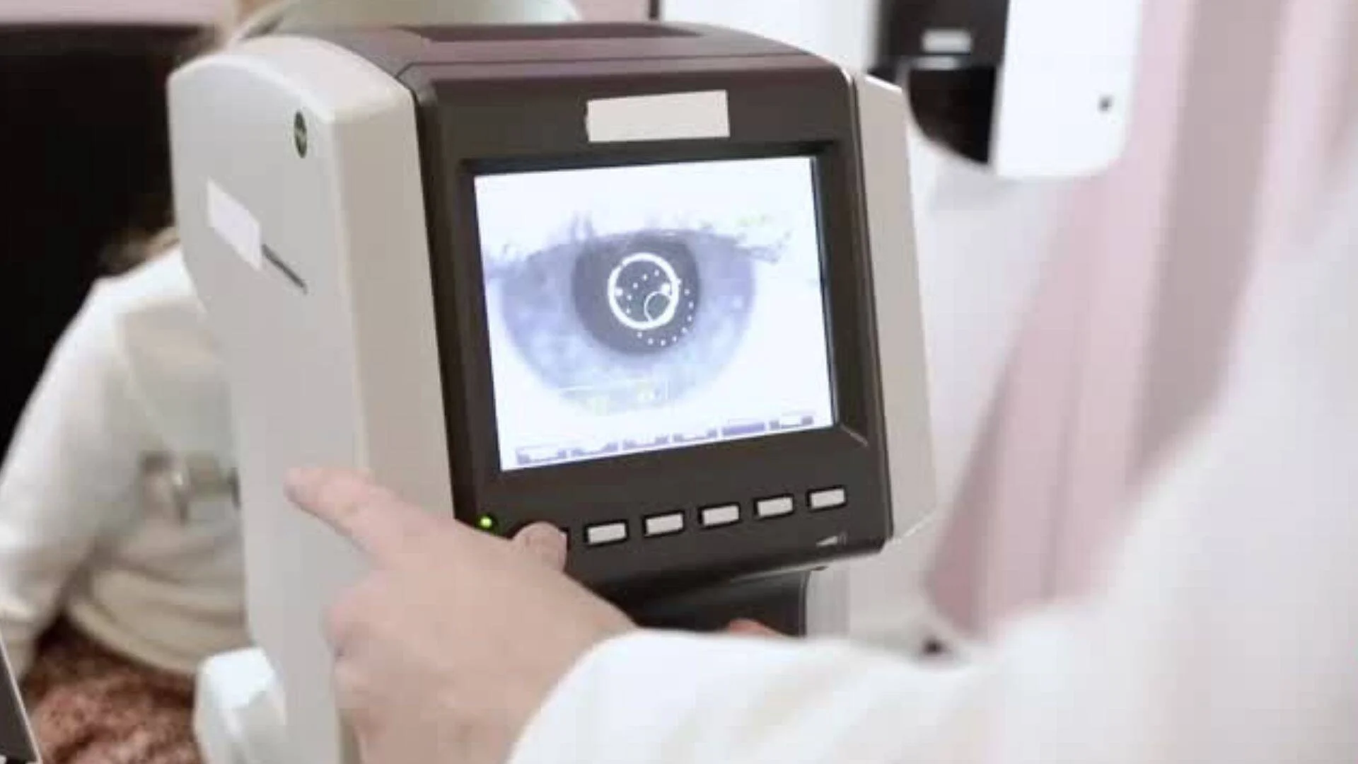 Dispositivo oftalmológico mostrando en su pantalla un primer plano del iris de un ojo durante un examen visual.