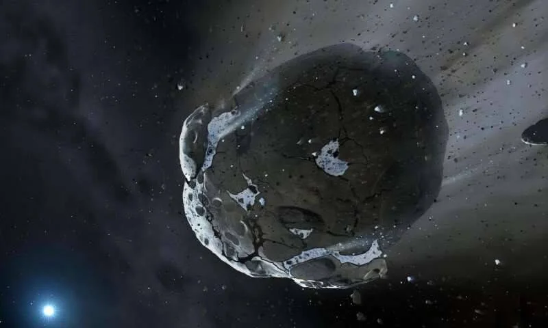 Recreación artística de un asteroide fragmentado con superficie agrietada desplazándose por el espacio cerca de una estrella brillante.