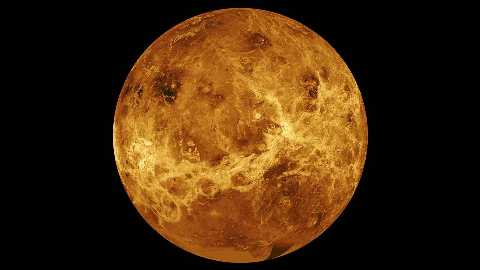 Imagen compuesta del planeta Venus mostrando su superficie rocosa en tonos dorados y marrones sobre fondo negro.