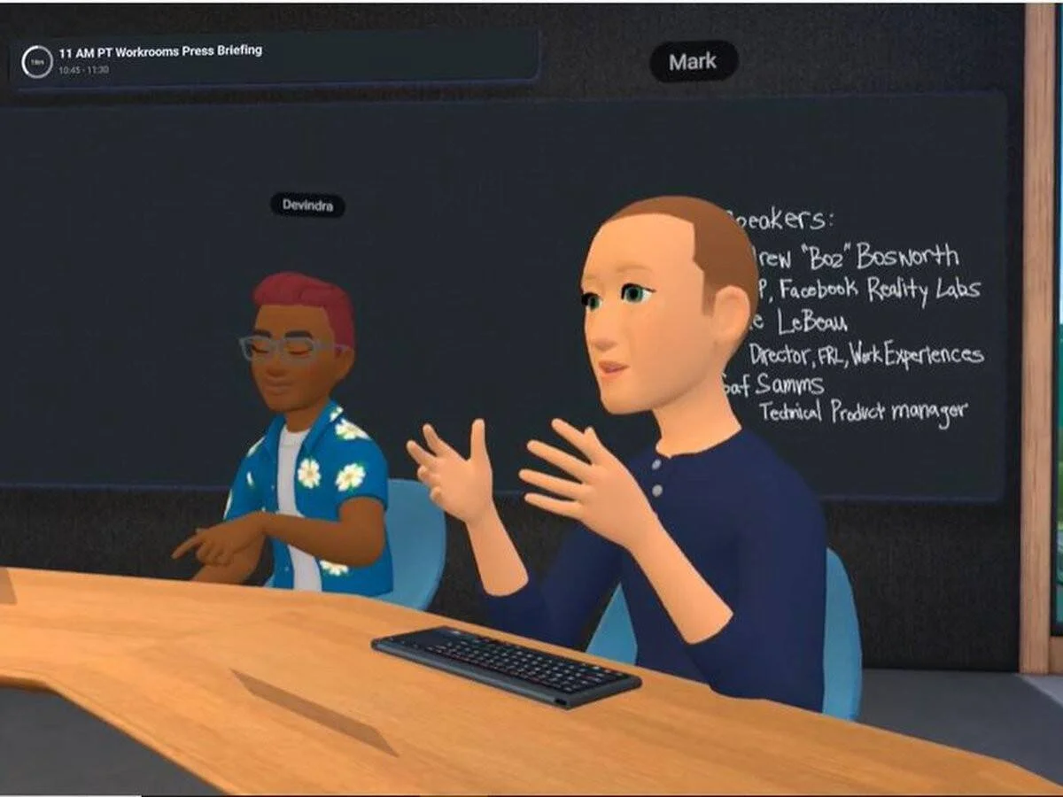 Dos avatares 3D participan en una videoconferencia virtual en Horizon Workrooms de Meta, con una pizarra de ponentes al fondo.