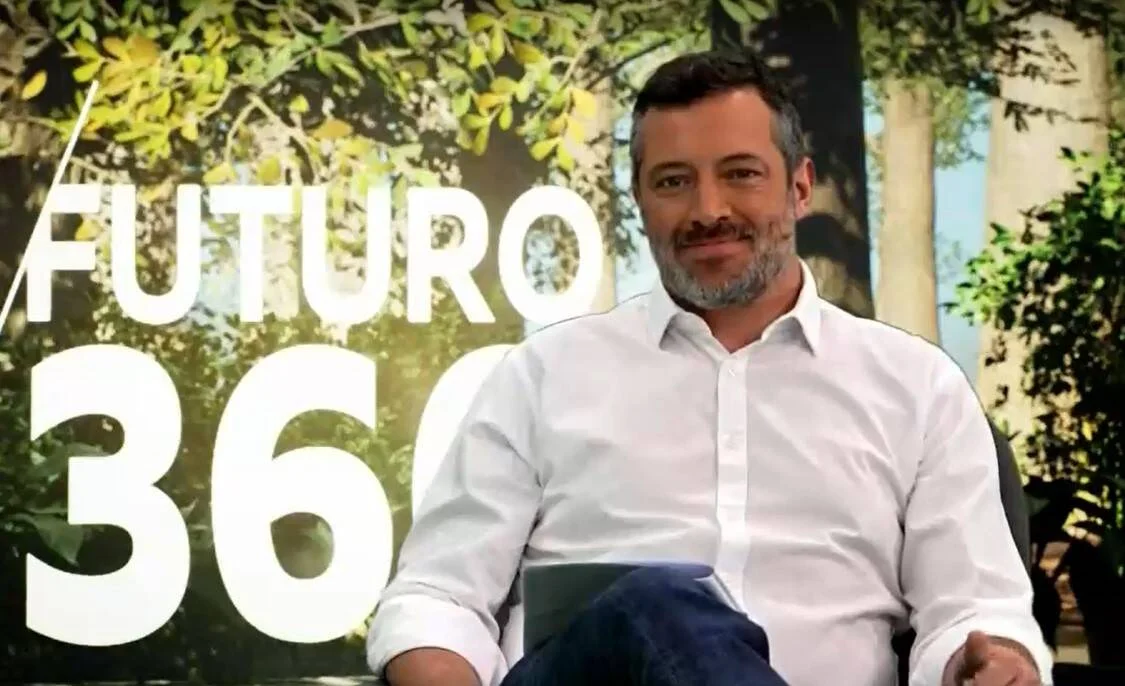Hombre con camisa blanca sentado frente a un fondo con el texto 'Futuro 360' y vegetación.