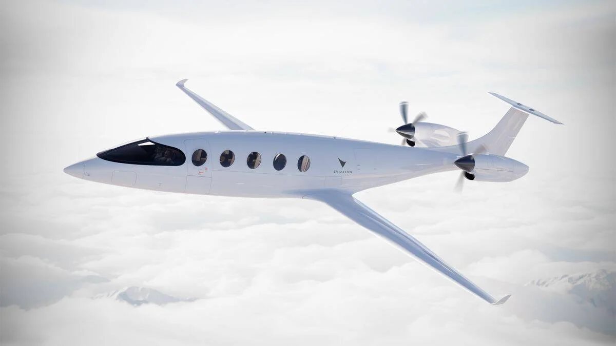 Avión eléctrico Eviation Alice de color blanco volando sobre un manto de nubes con sus hélices en movimiento.