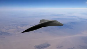 Renderizado conceptual de un dron militar de ala delta negra sobrevolando un vasto desierto a gran altitud.