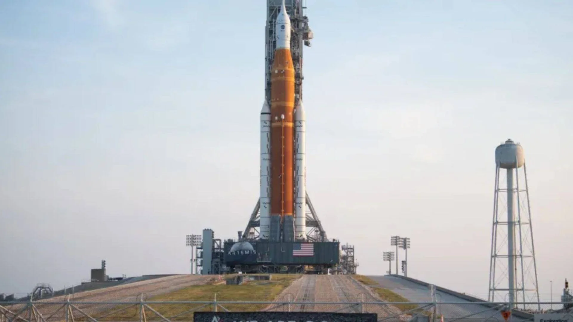El cohete SLS del programa Artemis de la NASA erguido en su plataforma de lanzamiento bajo un cielo despejado.