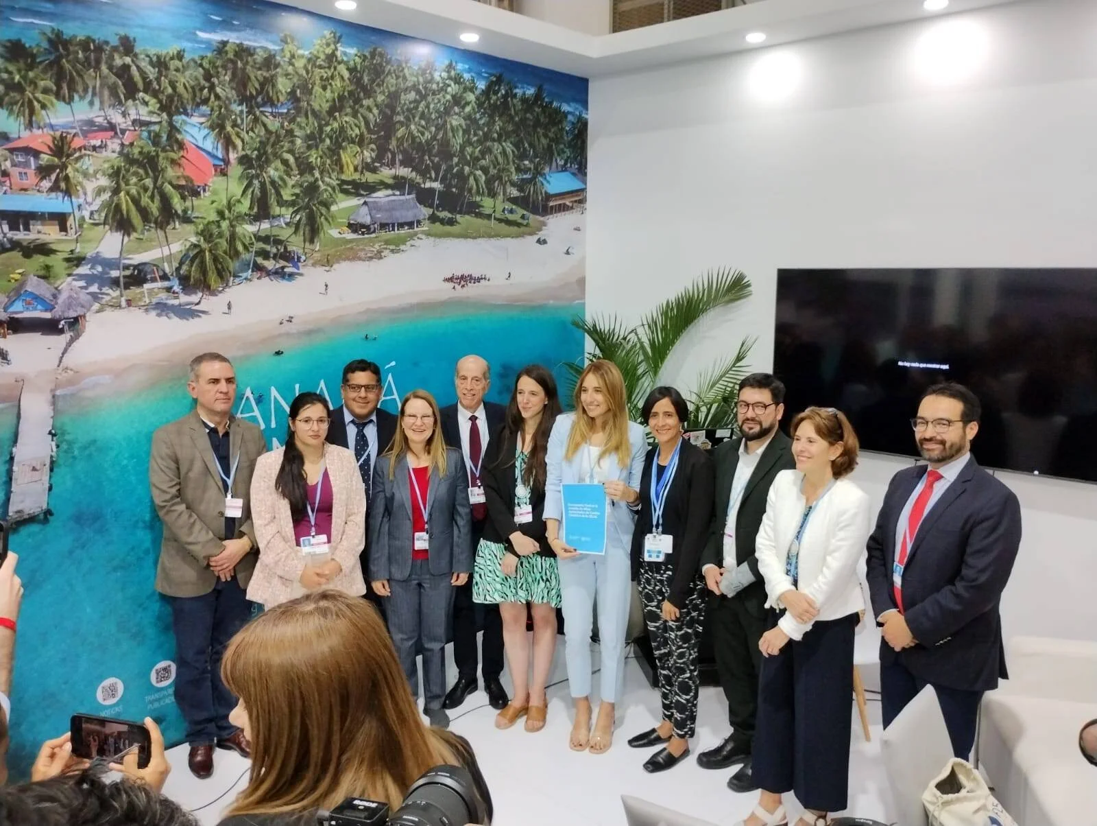 Grupo de funcionarios acreditados posan para una foto en el stand de Panamá durante un evento internacional.