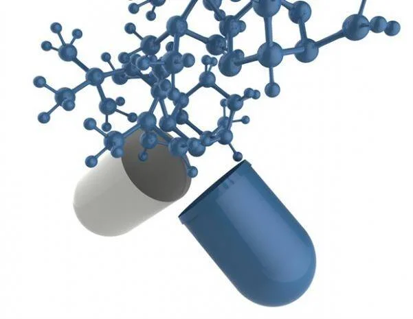 Cápsula medicinal abierta liberando una estructura molecular 3D azul, representando la composición química de un fármaco.