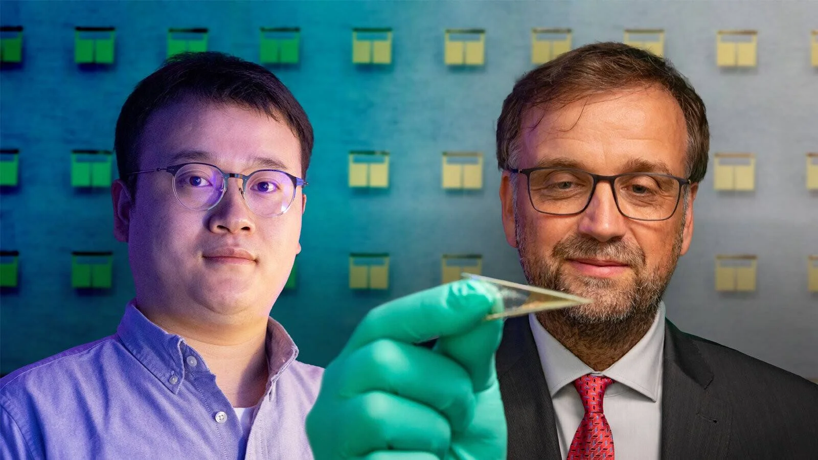 Dos científicos posan junto a una pequeña muestra transparente sostenida con guante de laboratorio, ante un fondo con celdas solares.