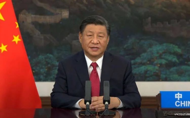 Dirigente chino habla ante micrófonos con la bandera de China y la Gran Muralla de fondo, en intervención ante la ONU.
