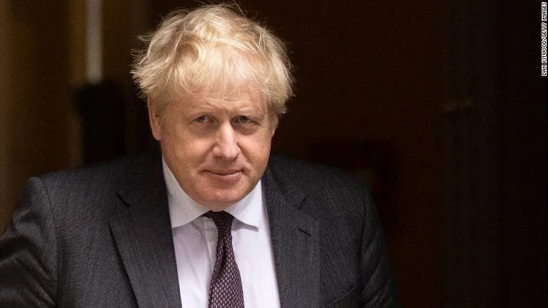 Boris Johnson, ex primer ministro del Reino Unido, con traje gris oscuro y cabello rubio despeinado.